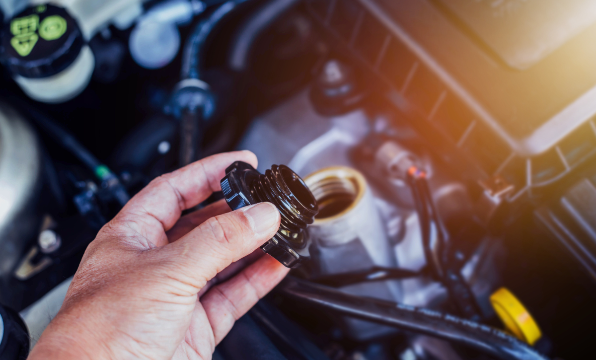 Mechanic checking and topping up vehicle fluid levels to maintain engine health