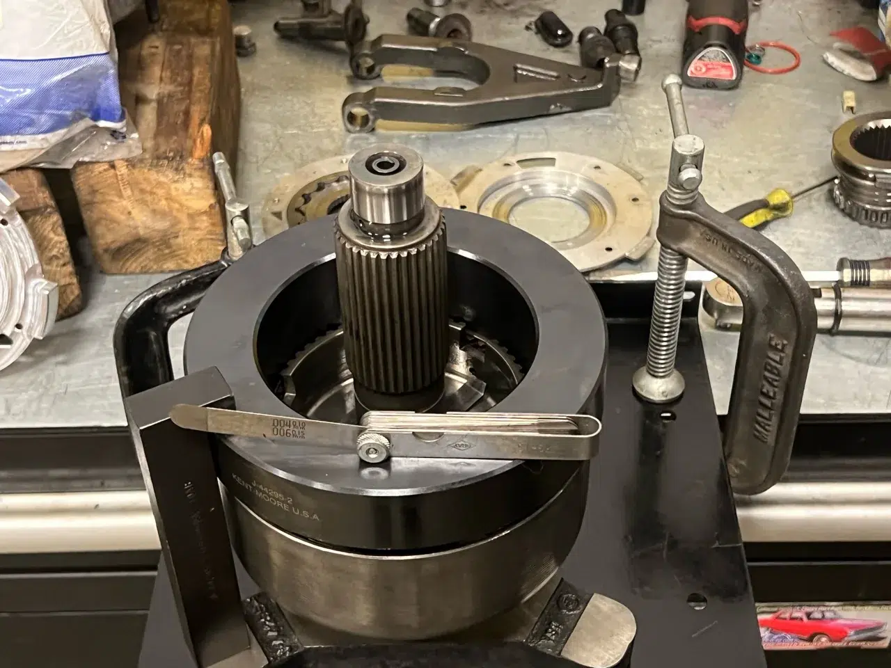 Transfer-case clutch assembly supported in a fixture with a gauge across the top